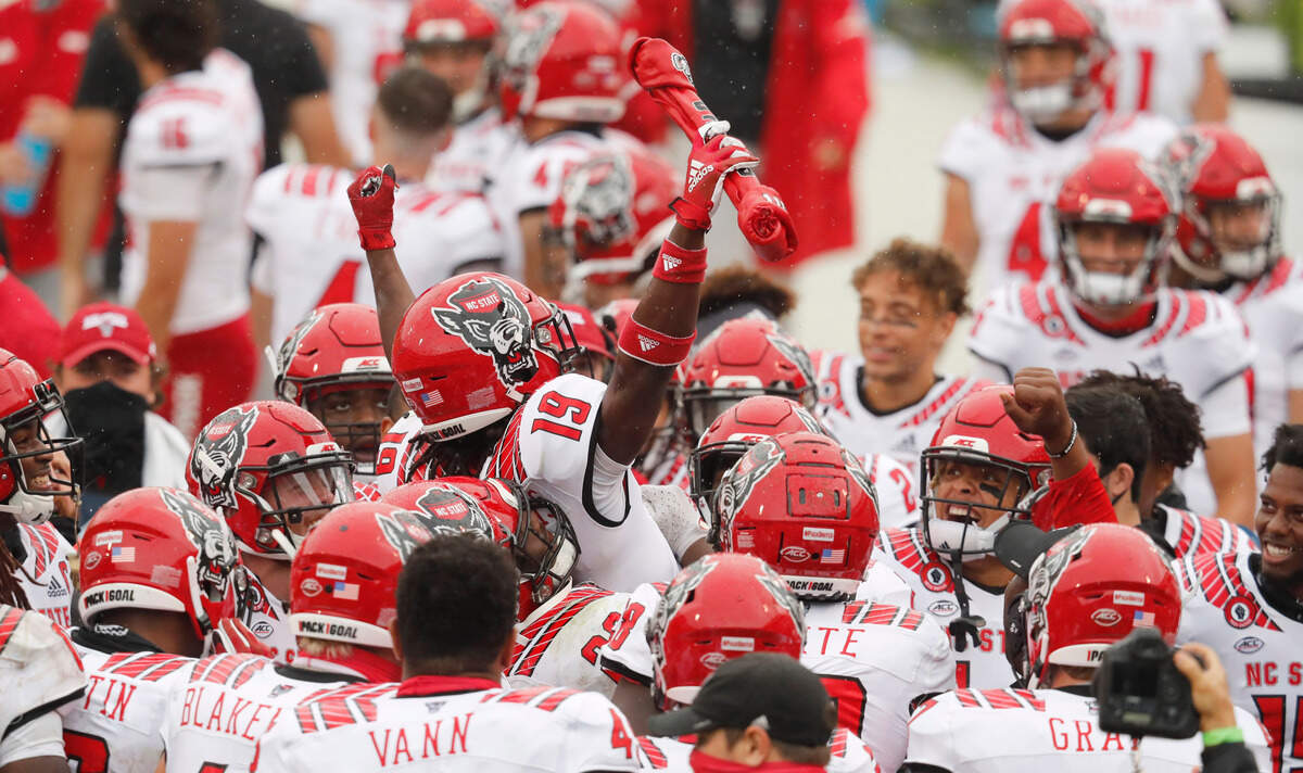 N.C. State defensive back Joshua Pierre-Louis (19) celebrates with teammates after intercepting the ball during the first half of N.C. State’s game against Virginia at Scott Stadium in Charlottesville, Va., Saturday, Oct. 10, 2020.