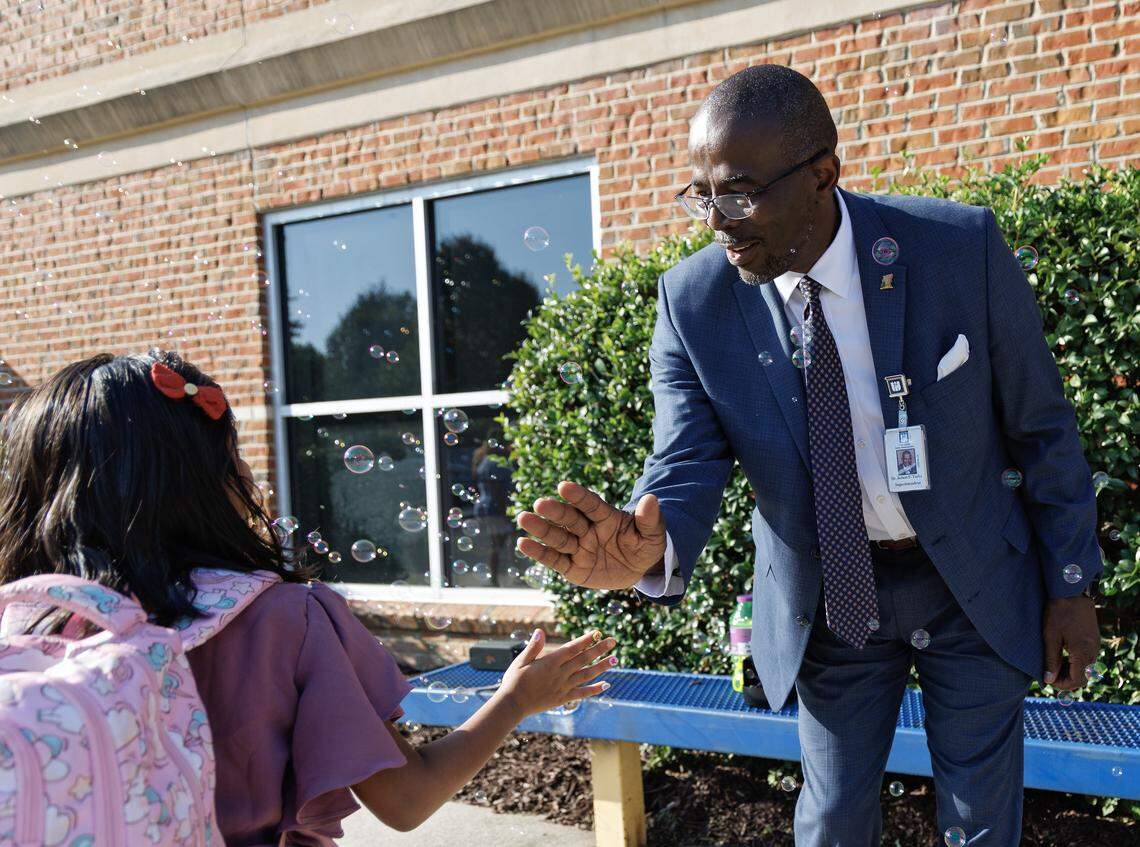 Wake County Superintendent Robert Taylor welcomes a student on the first day of school at Washington Elementary School on Monday, Aug. 25, 2025, in Raleigh, N.C.