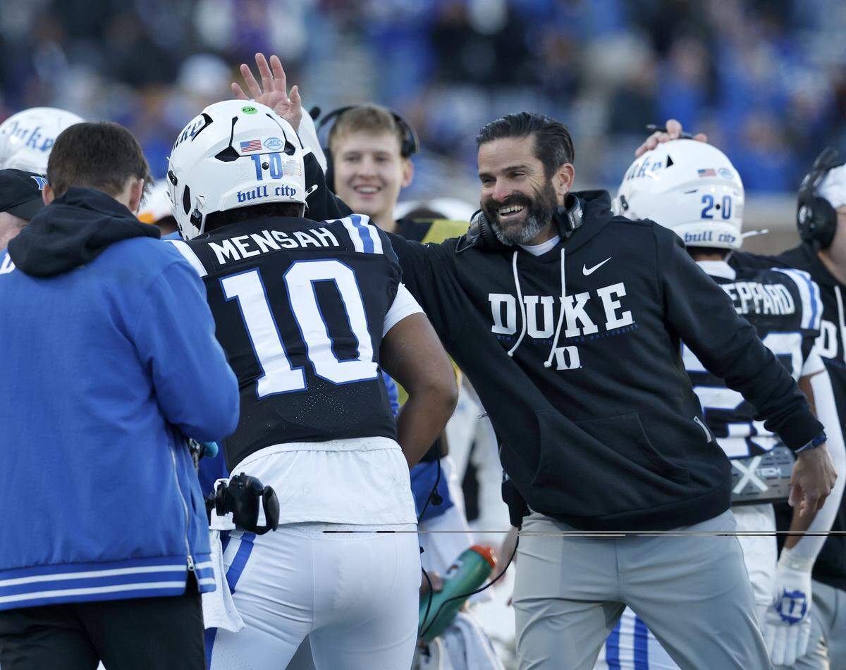 Duke head coach Manny Diaz congratulates quarterback Darian Mensah after he scored a touchdown during the first half of the Blue Devils’ game against Wake Forest on Saturday, Nov. 29, 2025, at Wallace Wade Stadium in Durham, N.C.