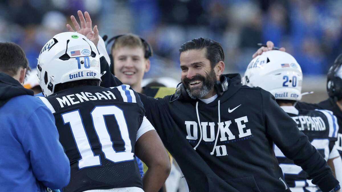 Duke head coach Manny Diaz congratulates quarterback Darian Mensah after he scored a touchdown during the first half of the Blue Devils’ game against Wake Forest on Saturday, Nov. 29, 2025, at Wallace Wade Stadium in Durham, N.C.