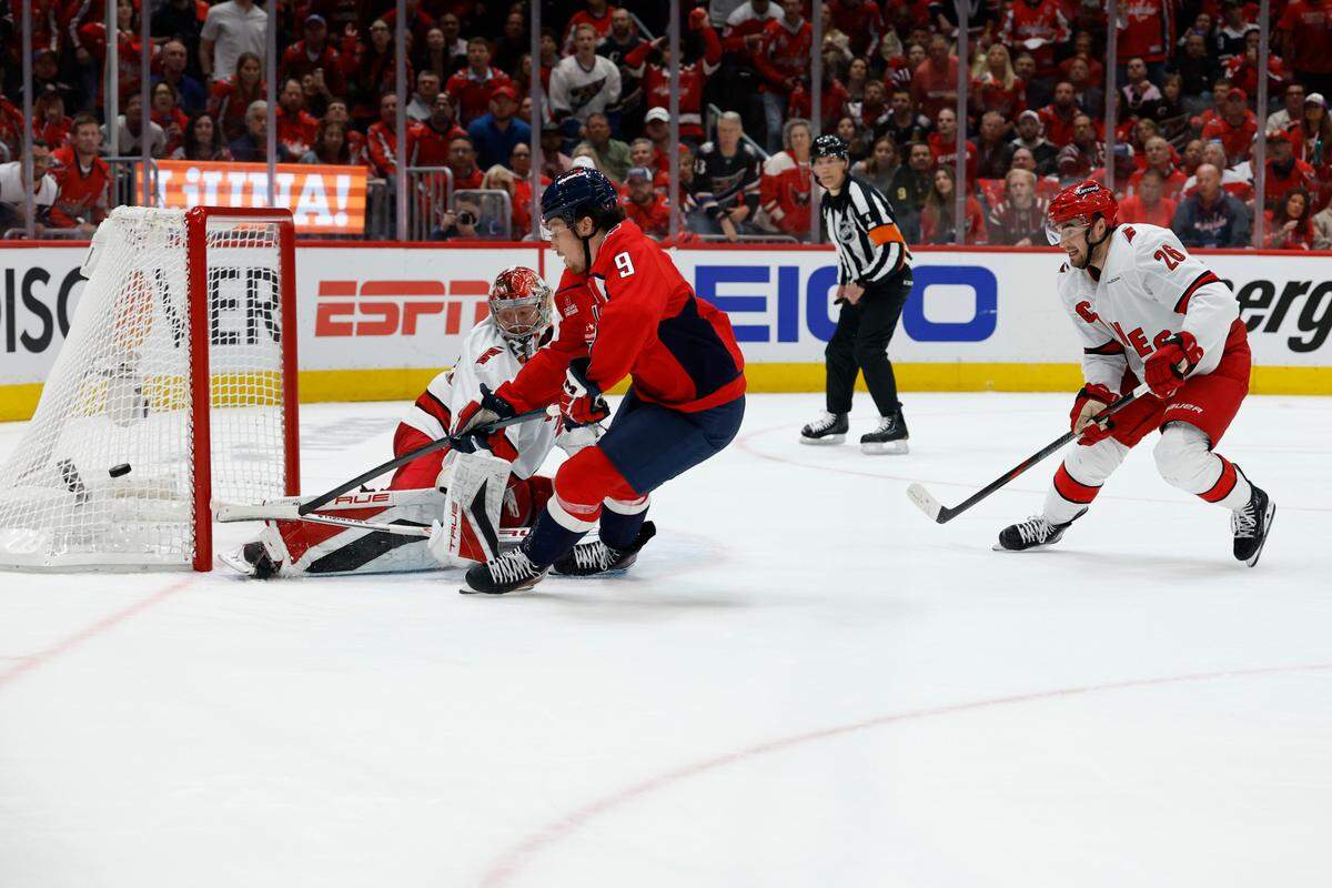 Washington Capitals right wing Ryan Leonard (9) shoots the puck on Carolina Hurricanes goaltender Frederik Andersen (31) as Hurricanes defenseman Sean Walker (26) chases in the third period in game one of the second round of the 2025 Stanley Cup Playoffs at Capital One Arena.
