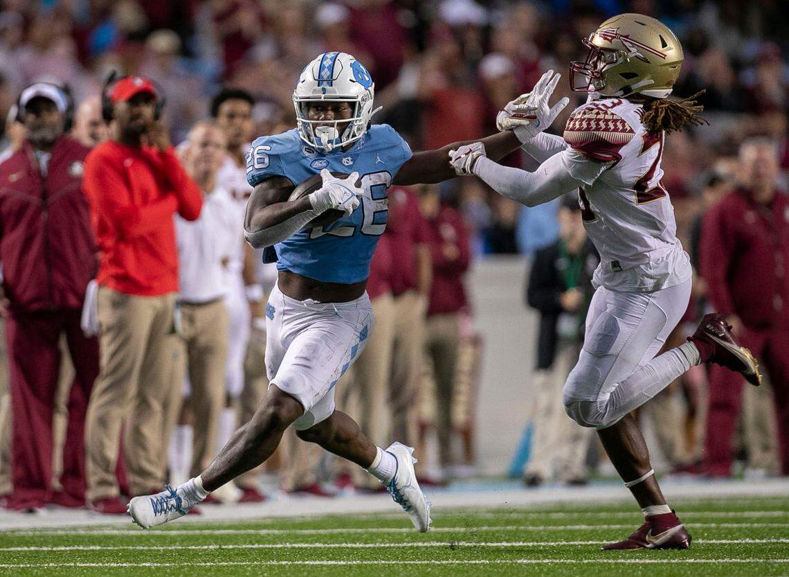 North Carolina’s D.J. Jones (26) picks up 15-yards ahead of Florida State’s Sidney Williams (23) in the third quarter on Saturday, October 9, 2021at Kenan Stadium in Chapel Hill, N.C.