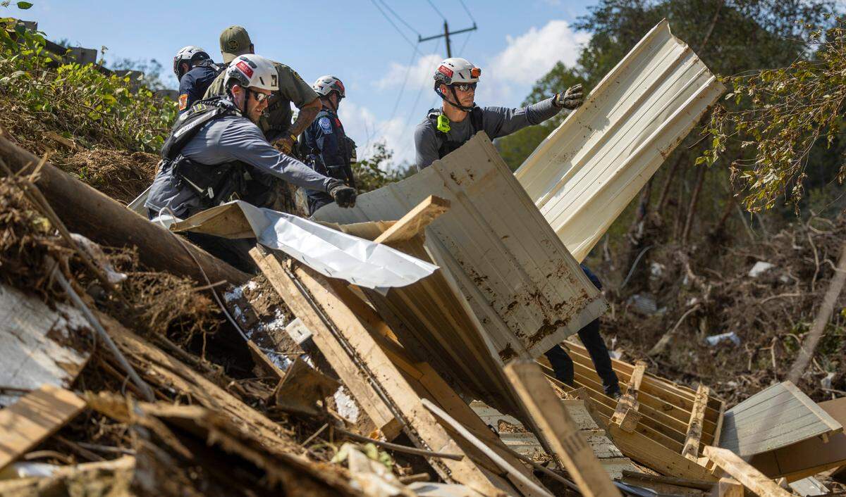 A FEMA search and rescue team from Maryland search for human remains in debris from a structure in Swannanoa on Sunday, Oct. 6, 2024 after Tropical Storm Helene flooded the Swannanoa River. North Carolina officials have confirmed 76 deaths from Tropical Storm Helene.