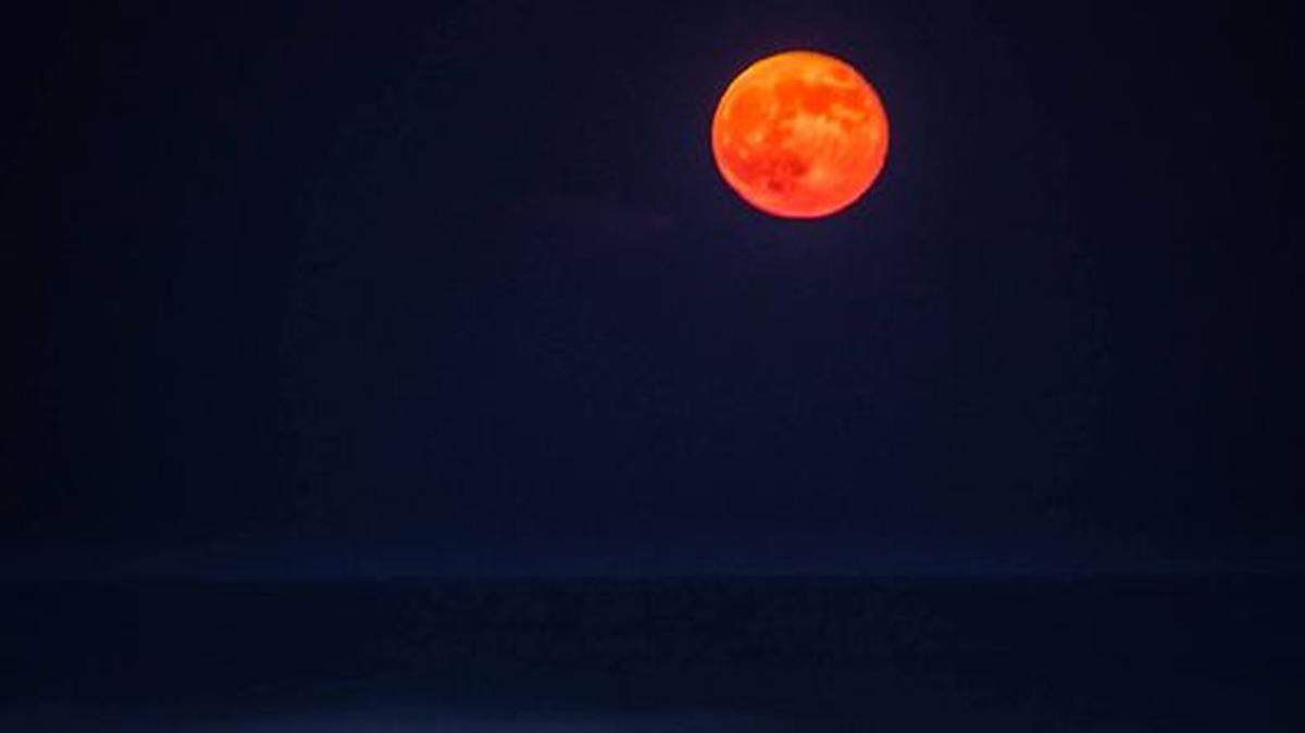 A supermoon shines above the dunes at Emerald Isle in July 2013.