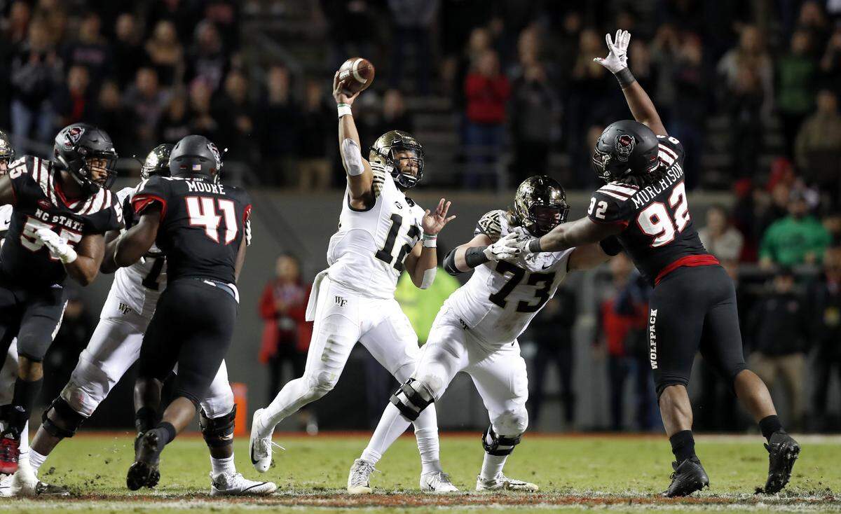 Wake Forest quarterback Jamie Newman (12) passes during the second half of Wake Forest’s 27-23 victory over N.C. State at Carter-Finley Stadium in Raleigh, N.C., Thursday, Nov. 8, 2018.