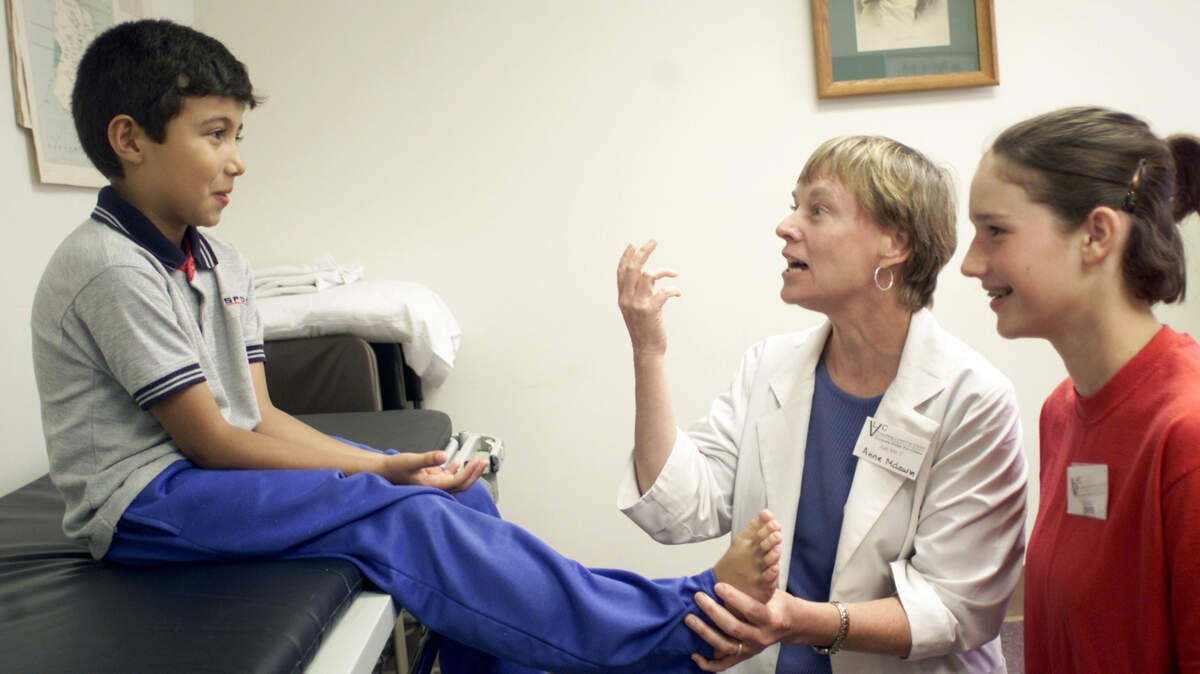 In this 2001 file photo, volunteering physician Dr. Anne McLaurin talks with Eduardo Amortegui of Raleigh, left, during Apex Baptist Church’s free medical clinic.