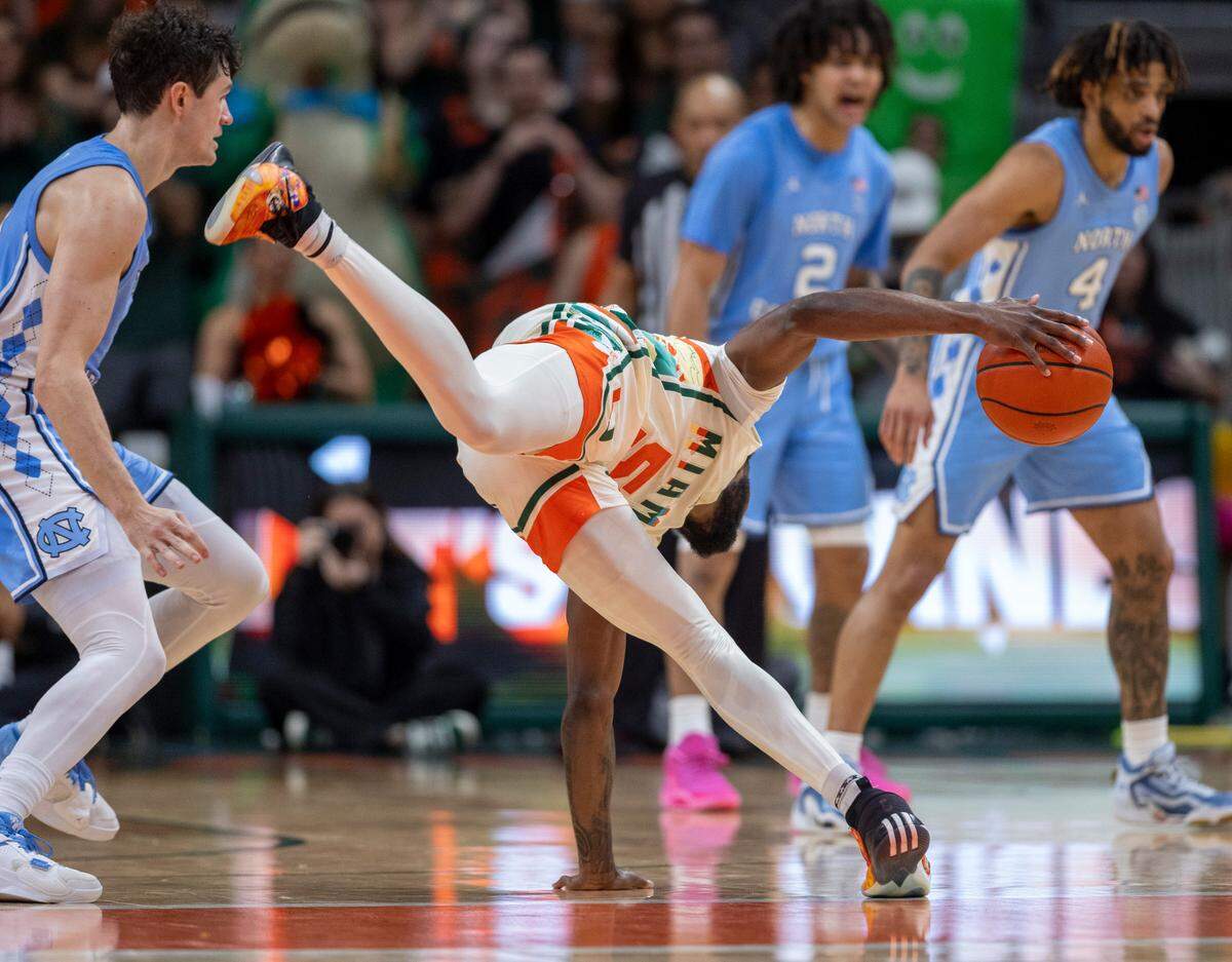 Miami’s Wooga Poplar (5) works to keep his balance after colliding with North Carolina’s Cormac Ryan (3) in the second half on Saturday, February 10, 2024 at the Watsco Center in Coral Gables, Florida.