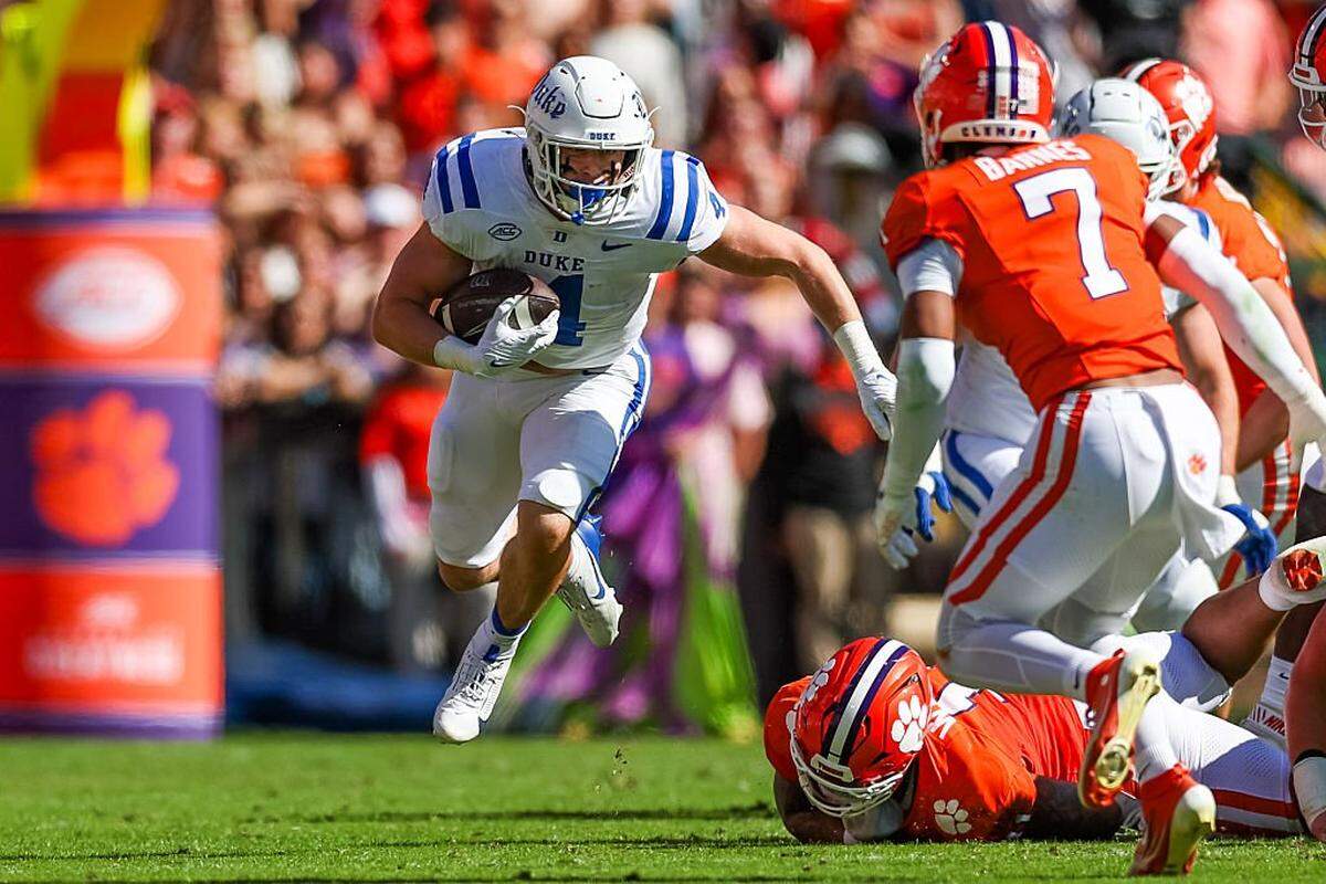 Anderson Castle (4) of the Duke Blue Devils runs the ball by Khalil Barnes (7) of the Clemson Tigers during the first half of a football game at Memorial Stadium on Nov. 1, 2025 in Clemson, South Carolina.