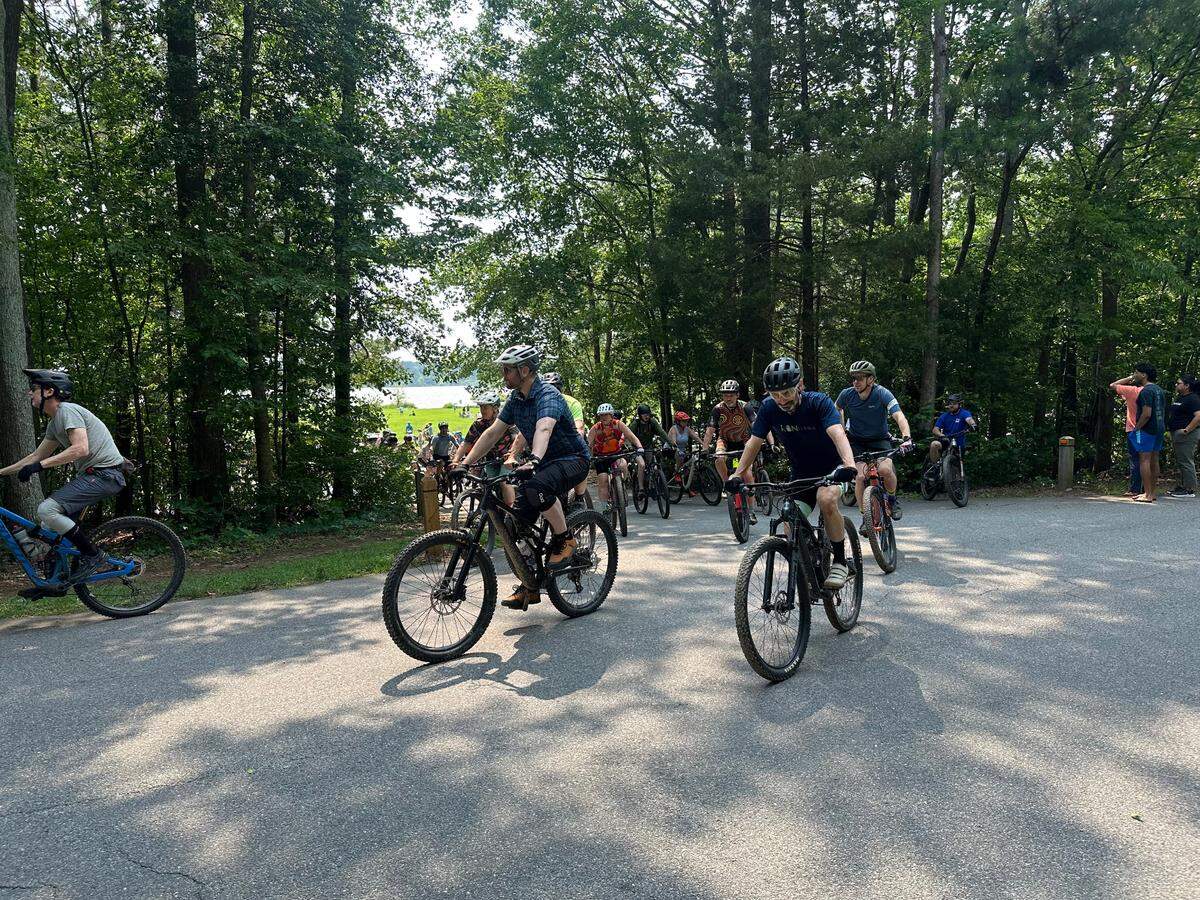Hundreds of off-road cyclists head out for one final group ride at Lake Crabtree County Park on Saturday May 31, 2025. Wake County closed the trails the following day, a month before its lease with Raleigh-Durham International Airport expires.
