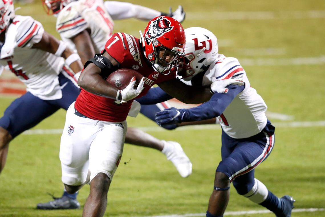 N.C. State running back Zonovan ‘Bam’ Knight (7) beats Liberty safety Benjamin Alexander (17) on his way to score on a 17-yard touchdown run during the first half of N.C. State’s game against Liberty at Carter-Finley Stadium in Raleigh, N.C., Saturday, Nov. 21, 2020.