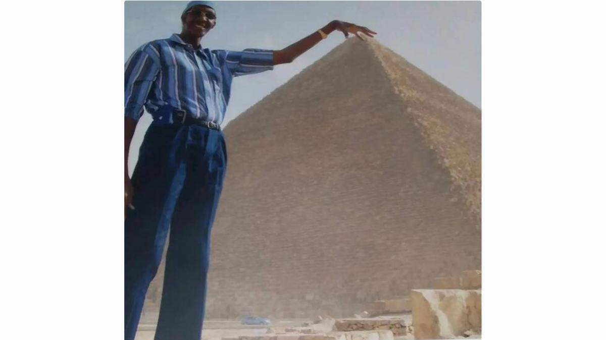 George Bell, shown here having a some optical illusion fun at the Great Pyramids in Egypt, stood 7 feet, 8 inches tall.