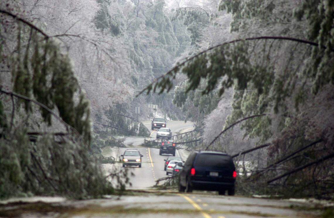 Looking northbound, traffic in both directions along NC Hwy. 55 south of Durham winds its way around fallen and drooping ice-laden trees Thursday afternoon after a major ice storm hit the area in December, 2002.