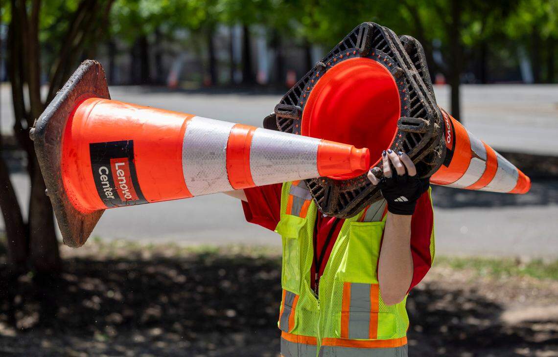 Simon Cassidy carries a stack of traffic cones as they are placed along Westchase Blvd. in preparation for the Linkin Park concert on Tuesday, May 6, 2025 at Lenovo Center in Raleigh, N.C. Lenovo Center employees place more than 2000 cones directing traffic to parking spots and exits for each event at the arena.