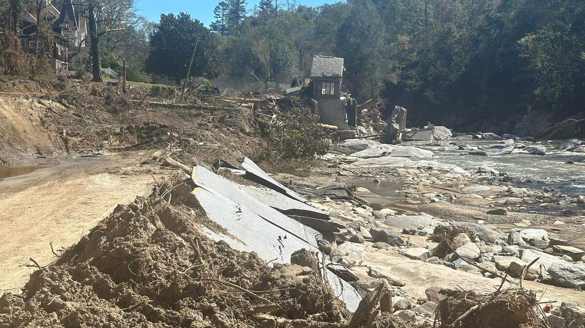 U.S. 64 where it passed in front of Caulder Realty & Land Co. in Bat Cave, North Carolina. The pavement is covered in several feet of mud and debris or, like most of the Caulder building, was washed away by the Rocky Broad River, right. Taken Thursday, Oct. 10, 2024.
