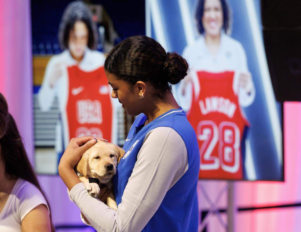 Duke’s Arianna Roberson holds a puppy prior to a ceremony honoring Kara Lawson as the 2025-2028 USA Basketball Women’s National Team head coach at Cameron Indoor Stadium on Tuesday, Sept. 23, 2025, in Durham, N.C.