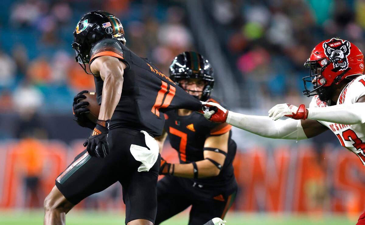 N.C. State’s Tyler Baker-Williams (13) tries to stop Miami wide receiver Charleston Rambo (11) during the first half of N.C. State’s game against Miami at Hard Rock Stadium in Miami Gardens, Fla. Saturday, Oct. 23, 2021.