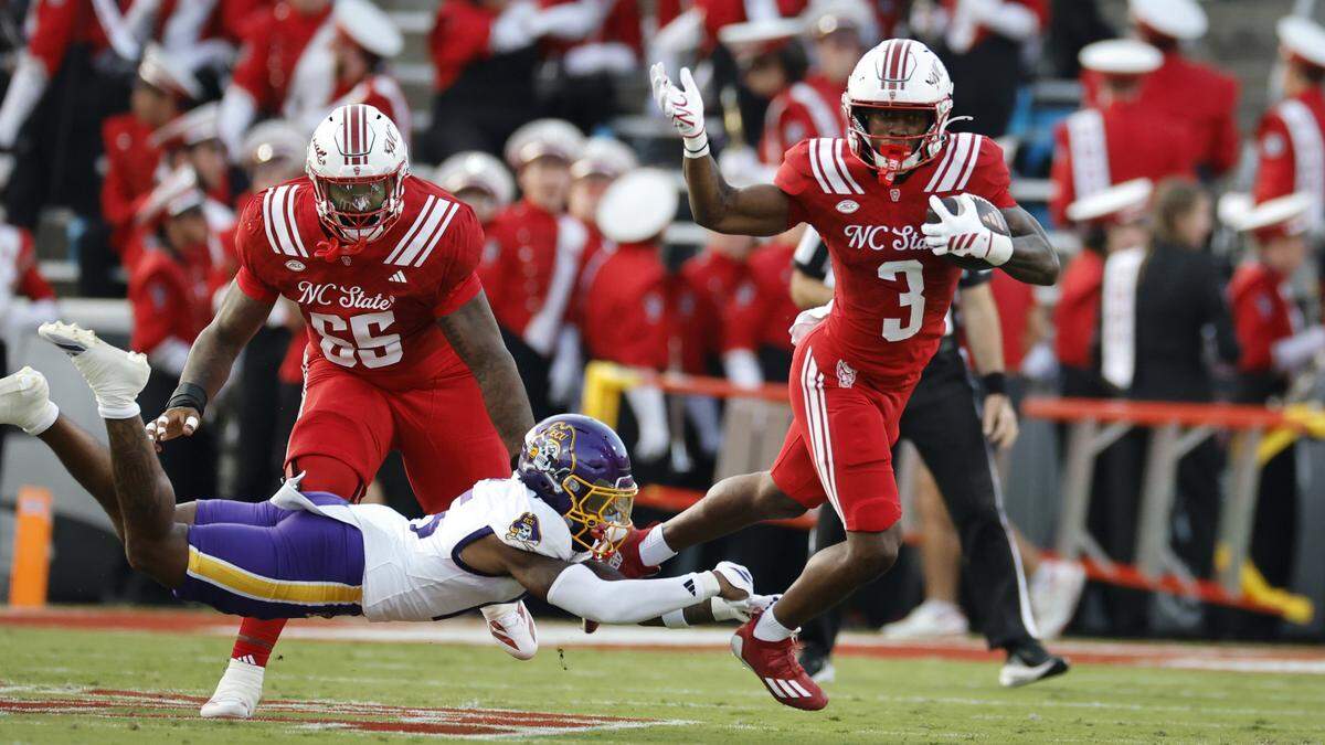 N.C. State running back Hollywood Smothers (3) tries to escape the tackle by East Carolina defensive back Jordy Lowery (15) during the first half of N.C. State’s game against ECU at Carter-Finley Stadium in Raleigh, N.C., Thursday, Aug. 28, 2025.