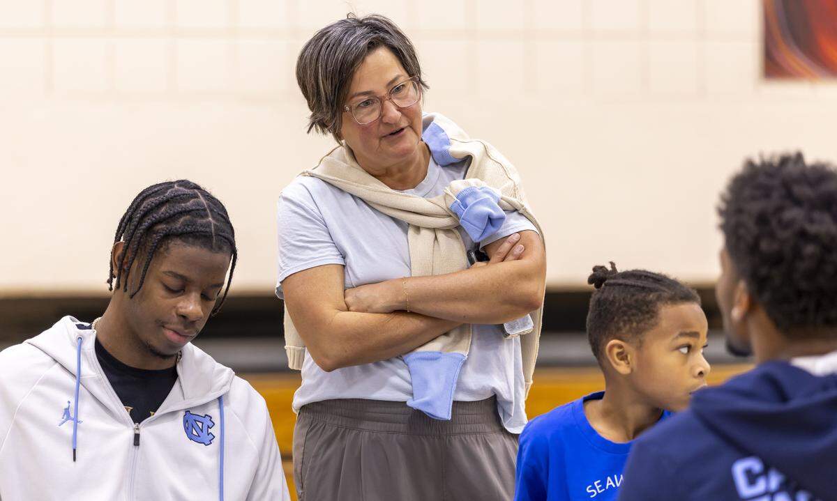 Leslie Davis talks with players Jaydon Young and Caleb Wilson as they works with children designing t-shirts for Black History Month at Hargraves Community Center on Wednesday, January 7, 2026 in Chapel Hill, N.C.
