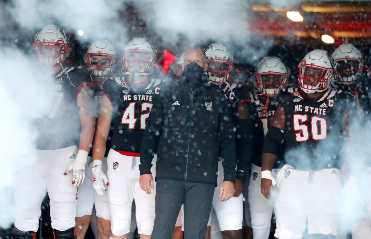 As the smoke which is part of the introduction starts, N.C. State head coach Dave Doeren prepares to lead to the team out onto the field before N.C. State’s game against Georgia Tech at Carter-Finley Stadium in Raleigh, N.C., Saturday, Dec. 5, 2020.