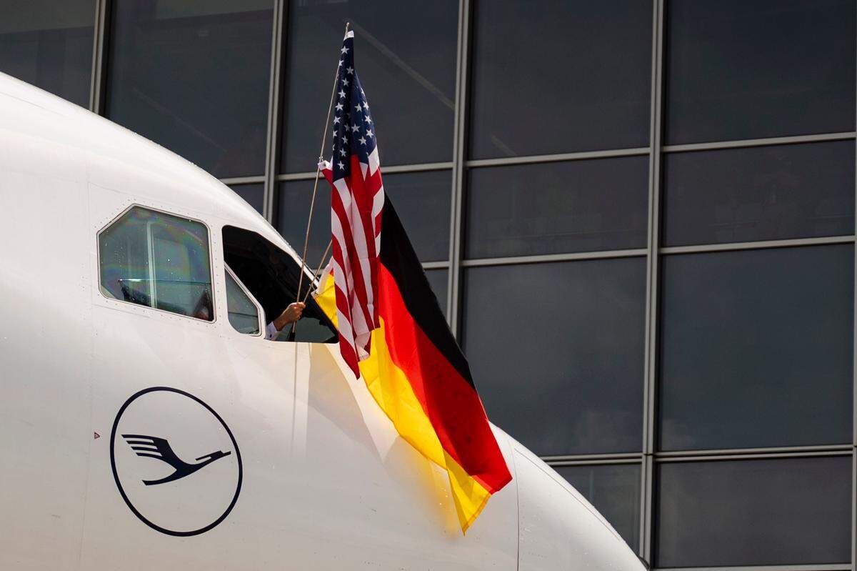 An American and German flag are waved out the window of the first Lufthansa flight from Frankfurt, Germany, to the Raleigh-Durham International Airport on June 6, 2024.