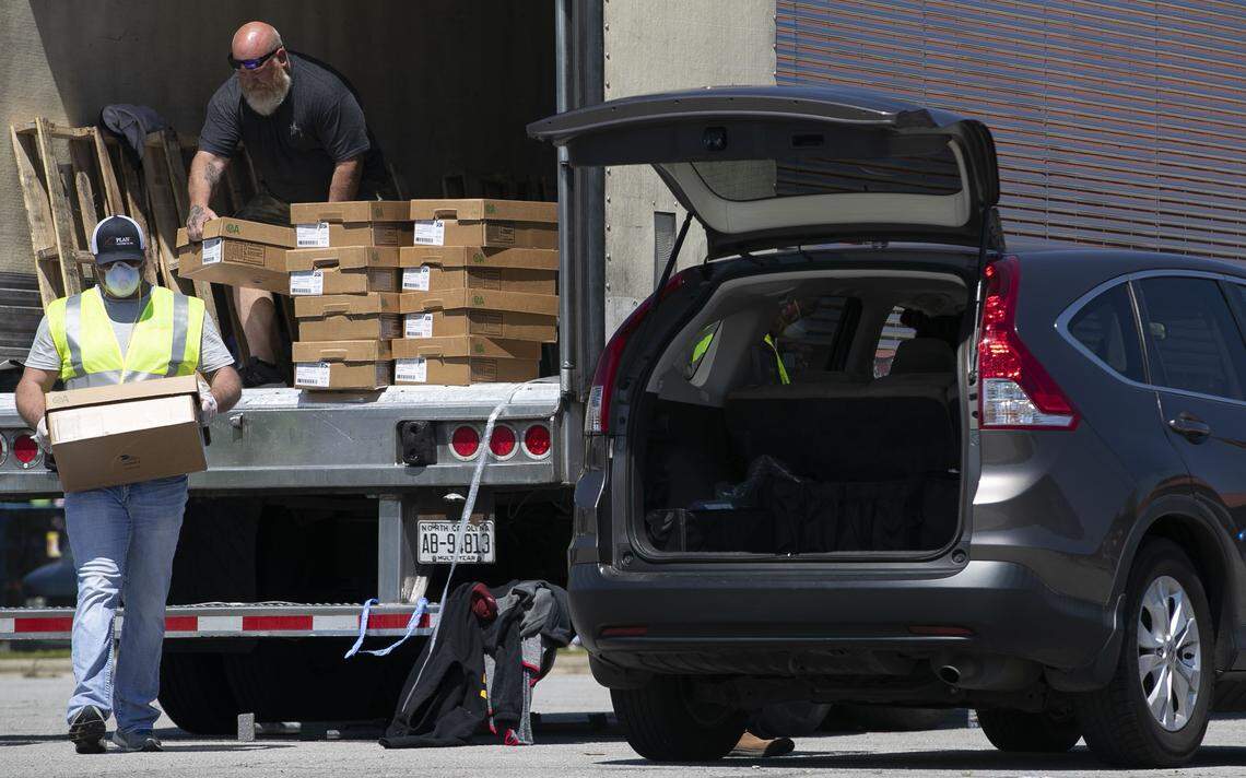 Ashley Duff loads a case of chicken in to a car during a massive chicken sale at the North Carolina State Farmers Market on Thursday morning April 16, 2020 in Raleigh, N.C. Chicken from House of Raeford was sold by the case. By mid-day Thursday, 1000 cases had been sold and another tractor trailer load arrived enabling the sale to continue into the afternoon.