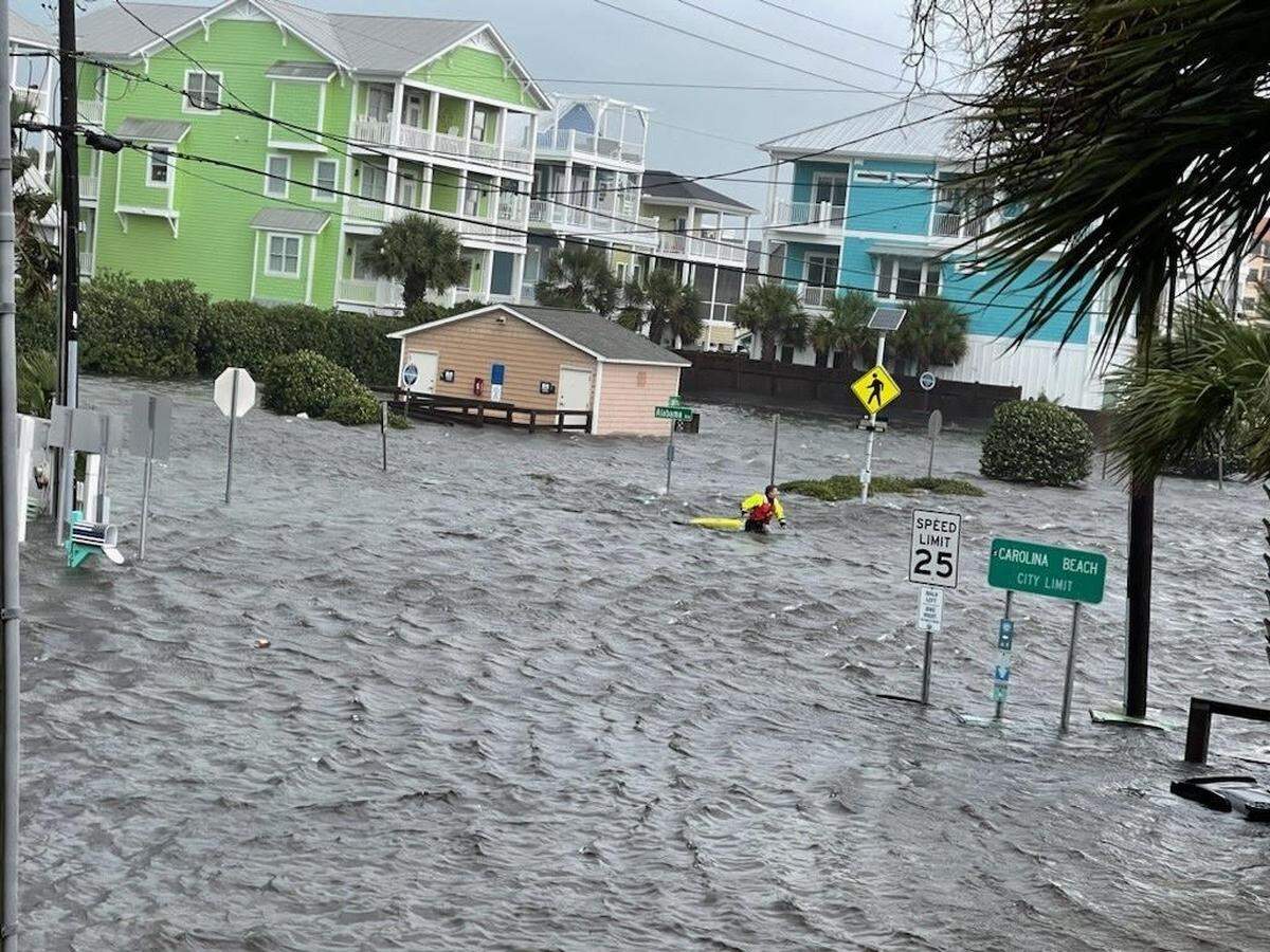 A man walks through nearly waist-deep water at Alabama Avenue and South Lake Park Boulevard in Carolina Beach Monday morning. The area south of Wilmington received more than 8 inches of rain between midnight and noon Monday from a low-pressure system off the coast.
