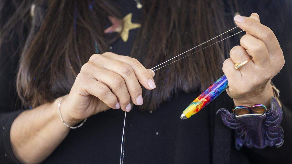 Leslie Stern prepares to apply fairy hair, metallic-like threads of tinsel, to her friend Liz Buno’s hair without compensation as a personal arrangement at Stern’s home in Durham.
