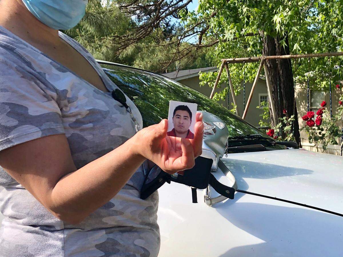 Ana Castillo holds a photo of her husband Liborio Rodriguez, outside of her home in Franklinton, NC. Rodriguez has been detained in the Stewart Detention Center in Lumpkin, Georgia since September 2019.