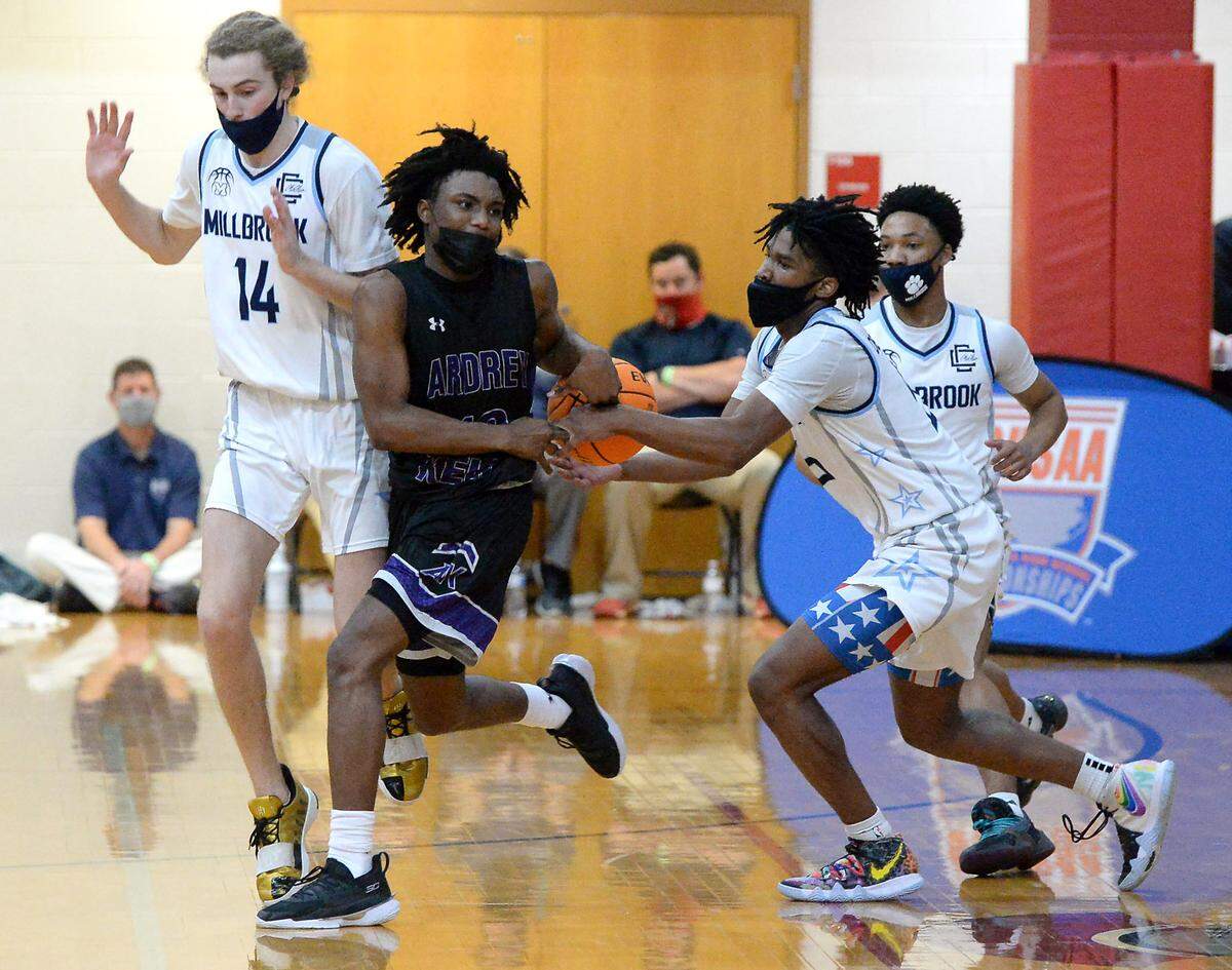 Millbrook’s Silas Demary, right, steals the ball from Ardrey Kell’s Knoah Carver, center, in the closing seconds of the 4A Boys NCHSAA Championship game at Wheatmore High School in Trinity, NC on Saturday, March 6, 2021. Demary then drove to the basket for the winning layup in the 67-65 victory over Ardrey Kell.
