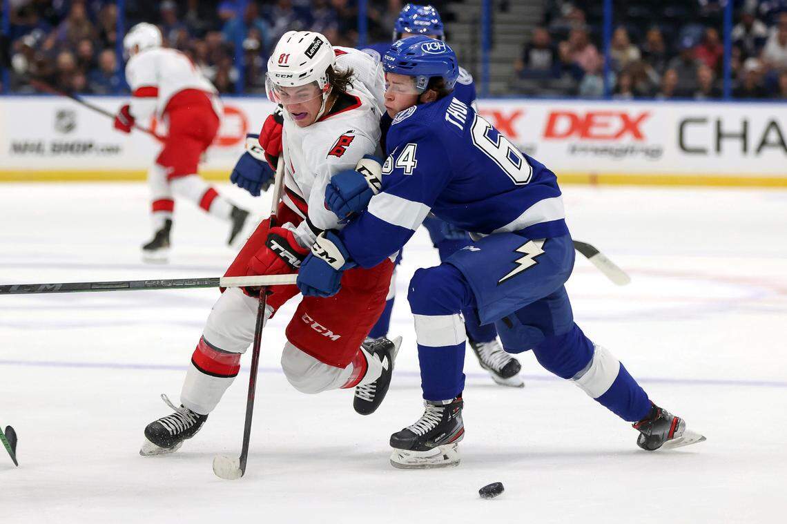 Carolina Hurricanes’ Jamieson Rees fights through the check of Tampa Bay Lightning’s Jack Thompson during the first period of a preseason NHL hockey game Friday, Oct. 1, 2021, in Tampa, Fla. (AP Photo/Mike Carlson)