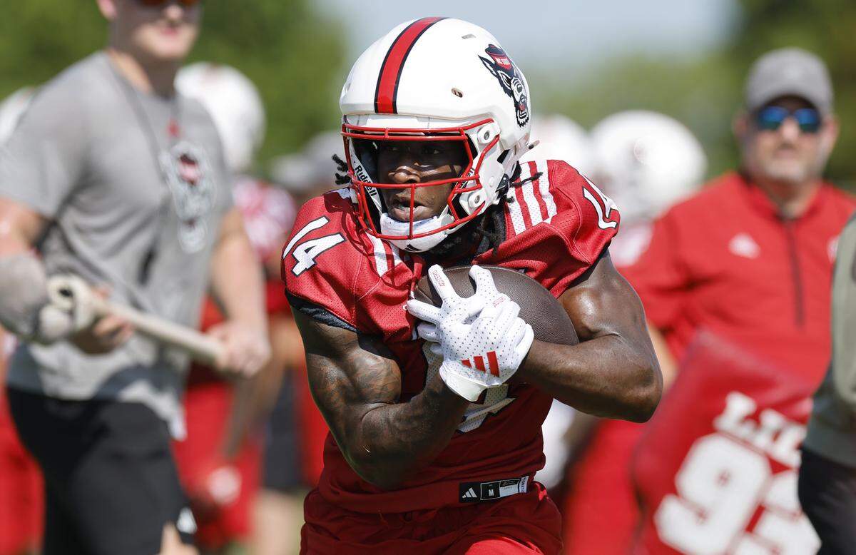 N.C. State’s Jonathan Paylor (14) keeps control of the ball during the Wolfpack’s first fall practice Wednesday, July 30, 2025.