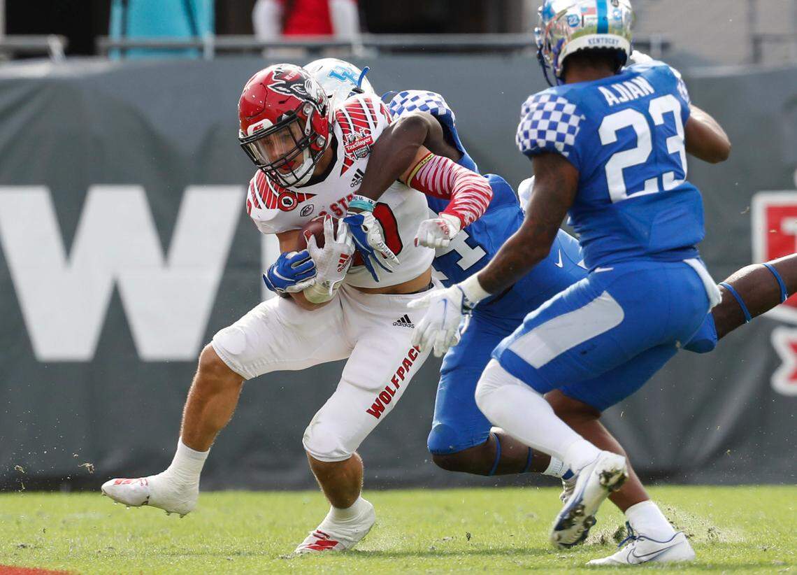 N.C. State running back Jordan Houston (20) is tackled by Kentucky linebacker Jamin Davis (44) during the first half of N.C. State’s game against Kentucky in the Gator Bowl at TIAA Bank Field in Jacksonville, Fla., Saturday, January 2, 2021.