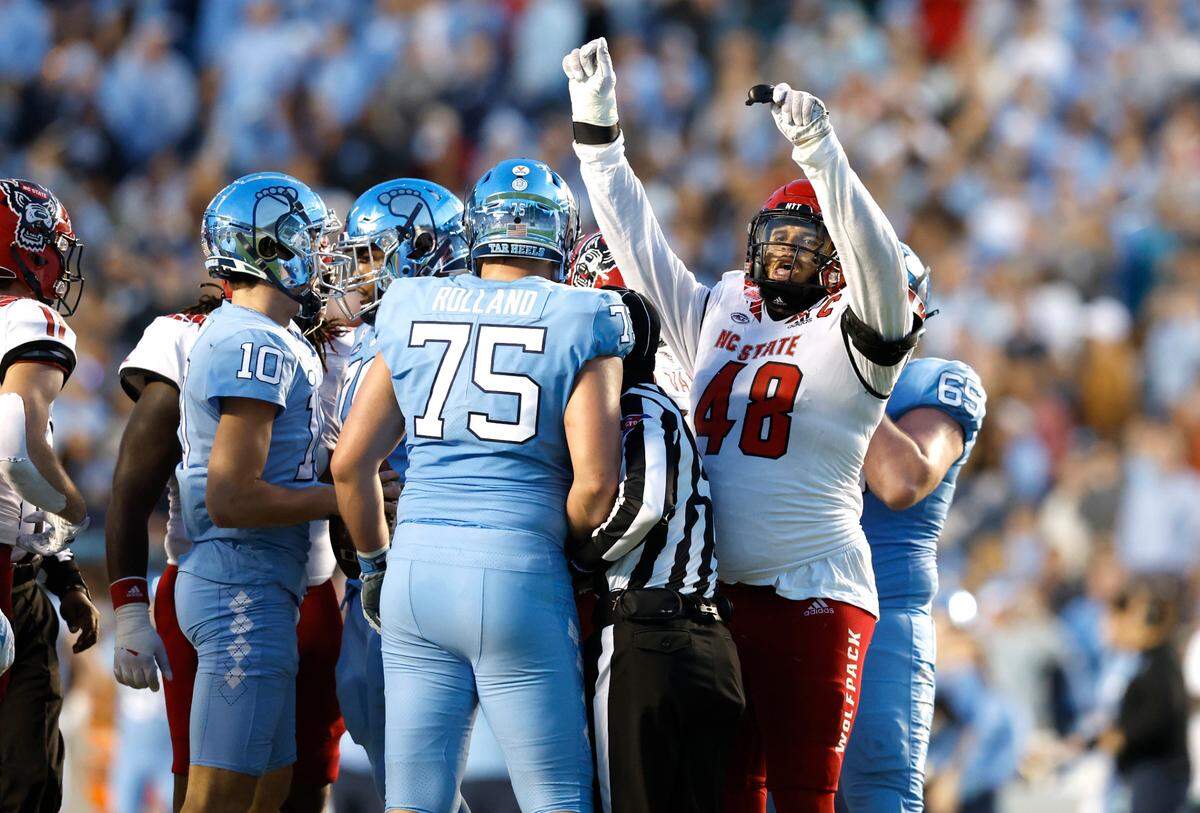 N.C. State defensive tackle Cory Durden (48) celebrates after North Carolina quarterback Drake Maye (10) was sacked during the first half of N.C. State’s game against UNC at Kenan Stadium in Chapel Hill, N.C., Friday, Nov. 25, 2022.