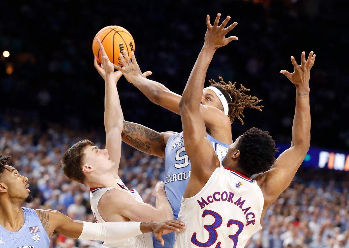 North Carolina’s Armando Bacot (5) shoots as Kansas’ Christian Braun (2) and David McCormack (33) defend during the first half of UNCs game against Kansas in the NCAA Mens National Championship at the Caesars Superdome in New Orleans, La., Monday, April 4, 2022.