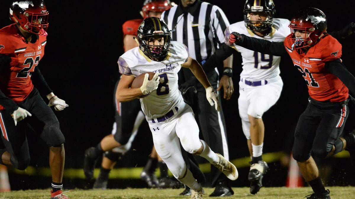 Dylan Waskey (8) of Holly Springs gains yards against Michael Macaluso (21) and Na’shawn Biggs (23) of Middle Creek. The Holly Springs Golden Hawks visited the Middle Creek Mustangs in a high school football game on October 18, 2019.