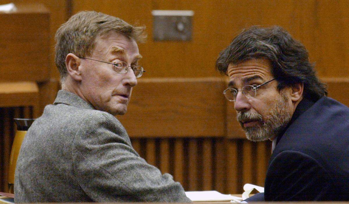 Michael Peterson (left) and his attorney David Rudolf look back at the Peterson children as Peterson made his first court appearance after being indicted in the death of his wife Kathleen Peterson. Judge Ronald Stephens did not set bail and Peterson would spend the next month in jail.