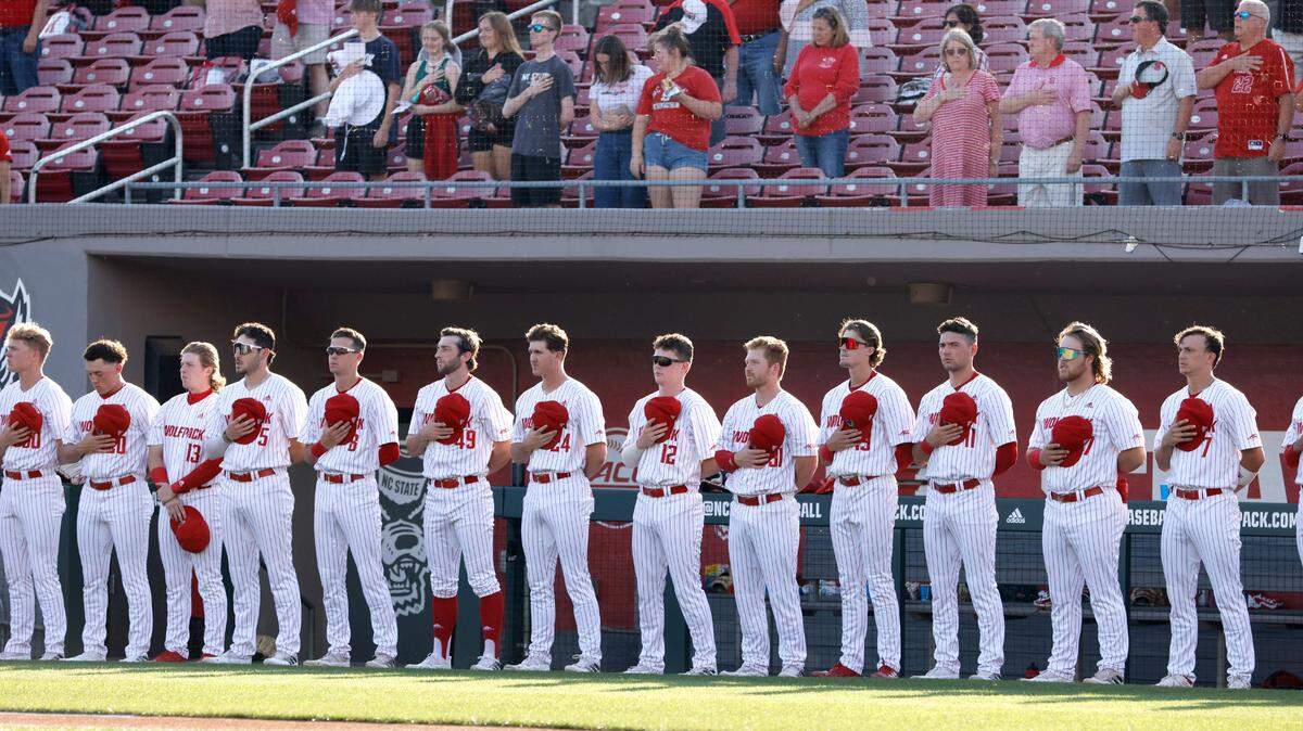 Wolfpack players listen to the national anthem before N.C. State’s game against UNC at Doak Field in Raleigh, N.C., Friday, May 6, 2022.