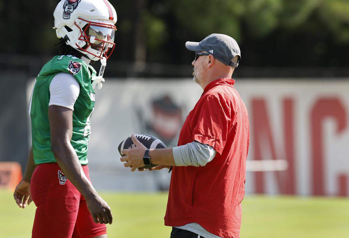 N.C. State offensive coordinator Kurt Roper talks with quarterback CJ Bailey (11) during the Wolfpack’s first fall practice Wednesday, July 30, 2025.