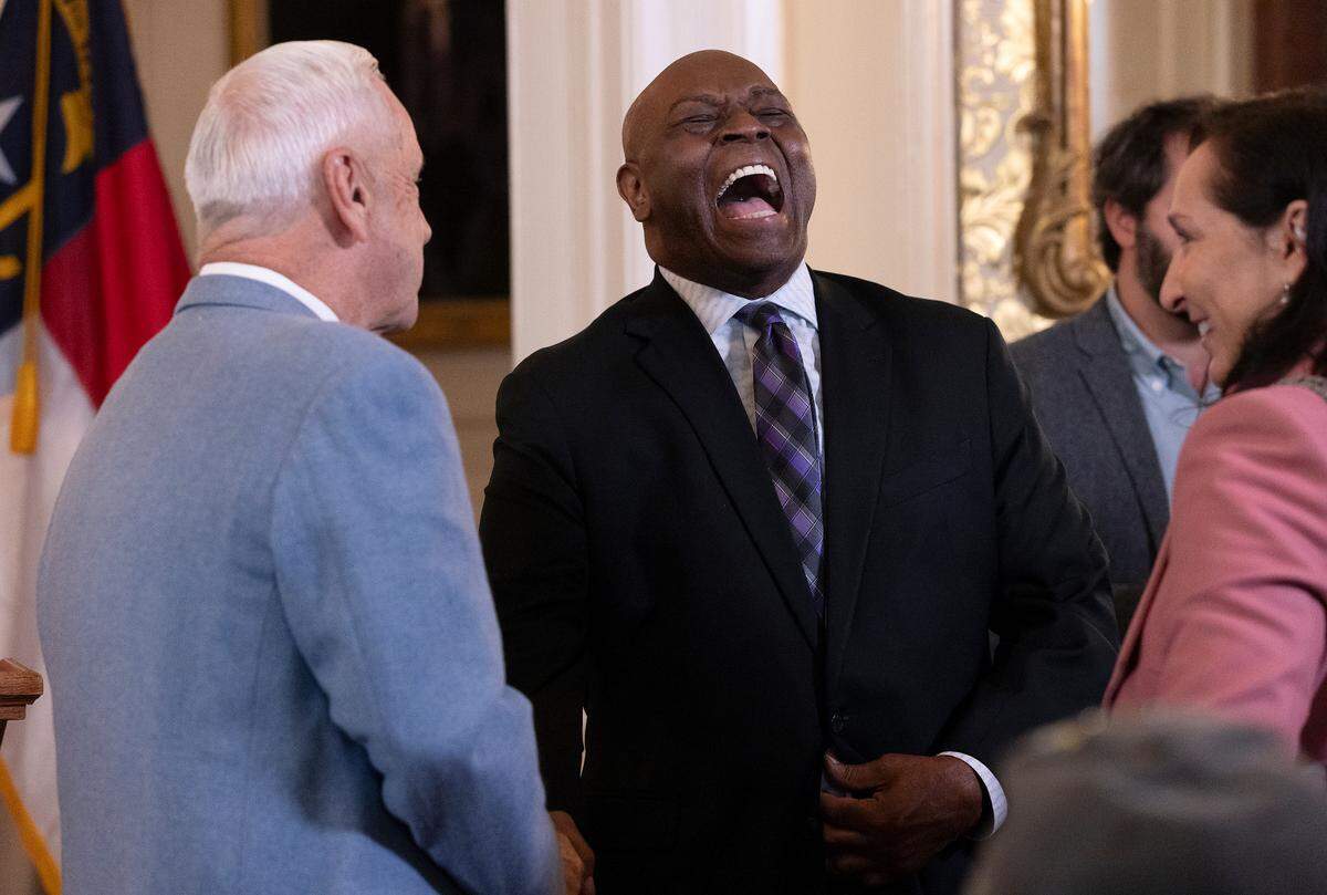 Former North Carolina basketball coach Roy Williams shares a laugh with former player and coach Phil Ford following a ceremony during which Williams was awarded The Order of the Long Leaf Pine at the Executive Mansion on Thursday, Dec. 19, 2024, in Raleigh, N.C.