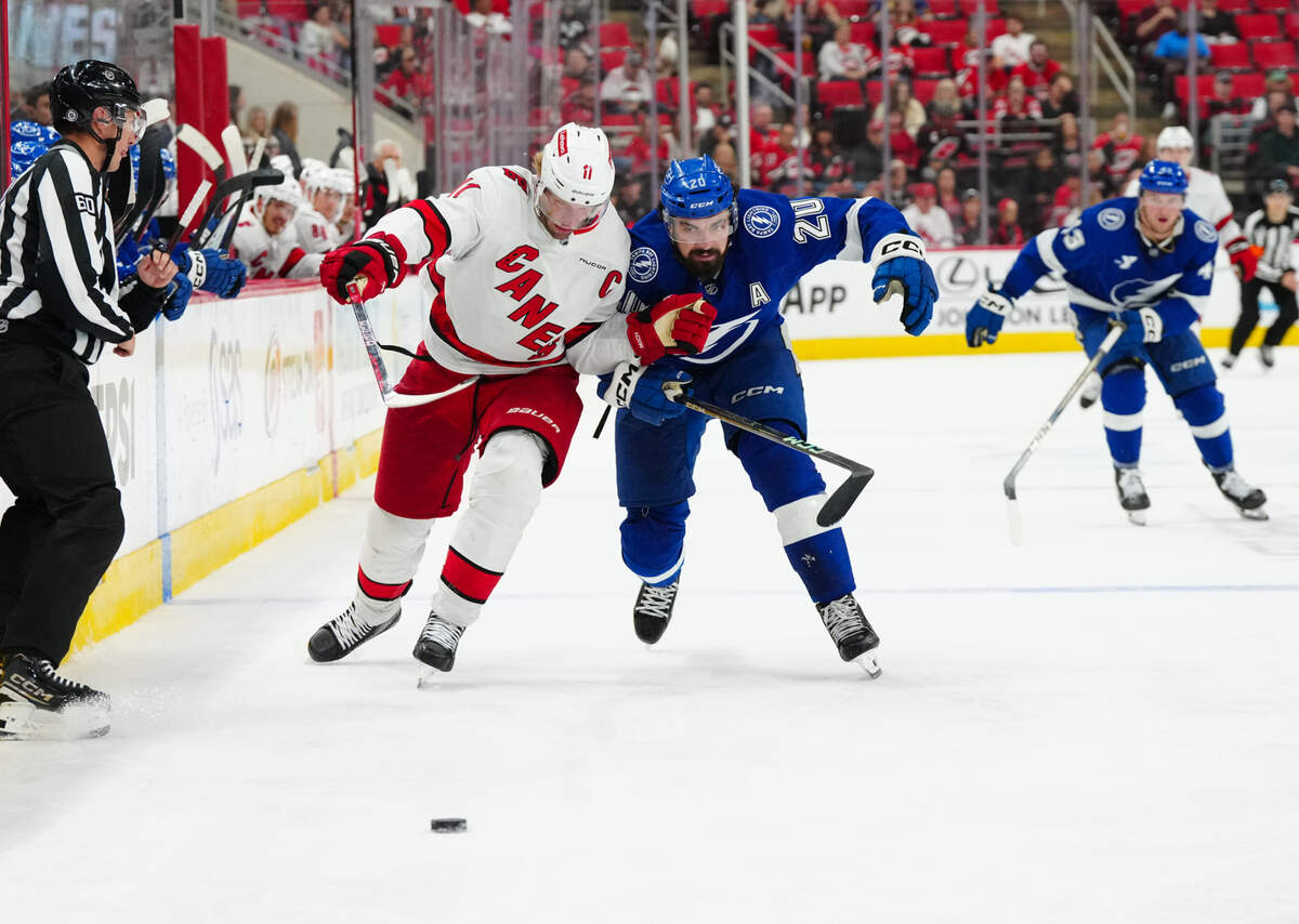 Oct 4, 2024; Raleigh, North Carolina, USA; Carolina Hurricanes center Jordan Staal (11) and Tampa Bay Lightning left wing Nicholas Paul (20) skate after the puck during the third period at PNC Arena.