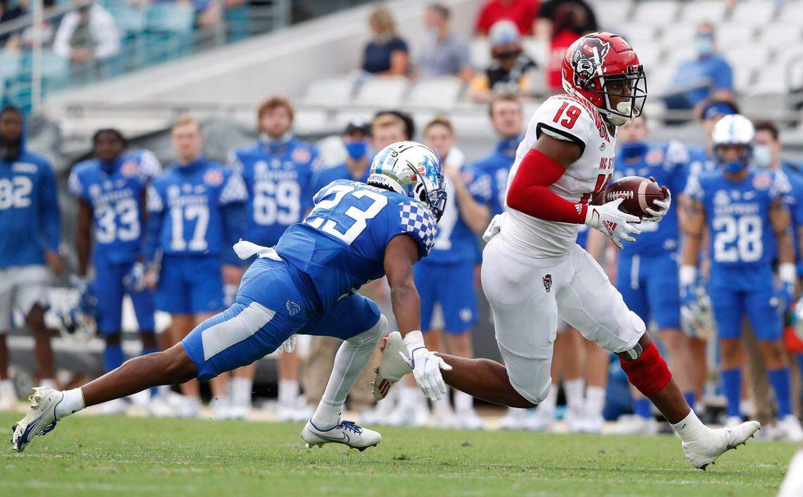 N.C. State wide receiver C.J. Riley (19) tries to break away from Kentucky defensive back Tyrell Ajian (23) during the second half of Kentucky’s 23-21 victory over N.C. State in the Gator Bowl at TIAA Bank Field in Jacksonville, Fla., Saturday, January 2, 2021.