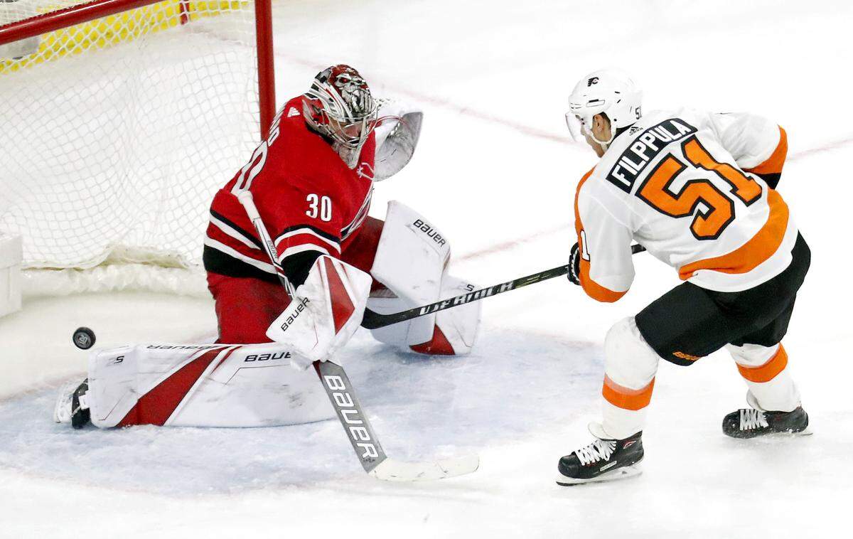 The Flyers' Valtteri Filppula (51) puts the puck past the Canes Cam Ward (30) for what proved to be the go ahead goal during the third period of an NHL game played between the Carolina Hurricanes and the Philadelphia Flyers at PNC Arena in Raleigh, N.C. on March 17, 2018.  The Flyers beat the Canes 4-2.