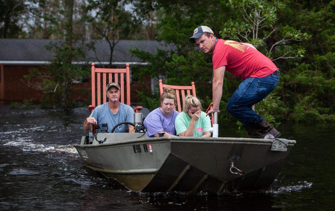 From left, Mike Haddock, 48, Katlyn Humphrey, 19, Michelle Haddock, 45, and Justin Humphrey, 24, remove possessions from the Haddock’s flooded home using a jon boat Monday, Sept. 17, 2018 in Trenton, NC following Hurricane Florence.