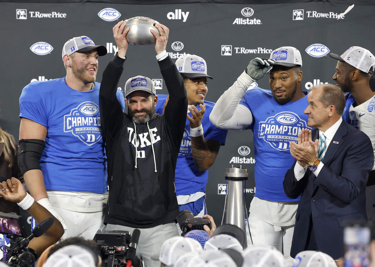 Duke head coach Manny Diaz celebrates with his team after being presented the ACC Football Championship trophy following the Blue Devils’ 27-20 overtime win over Virginia on Dec. 6, 2025, at Bank of America Stadium.