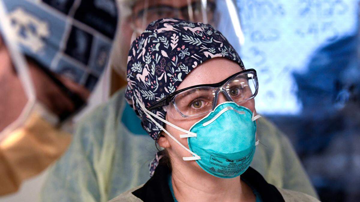 Dr. Lauren Raff listens to information from the team treating a COVID patient during morning rounds in the surgical/trauma ICU at UNC Hospital in Chapel Hill, N.C., Thursday, January 27, 2022.