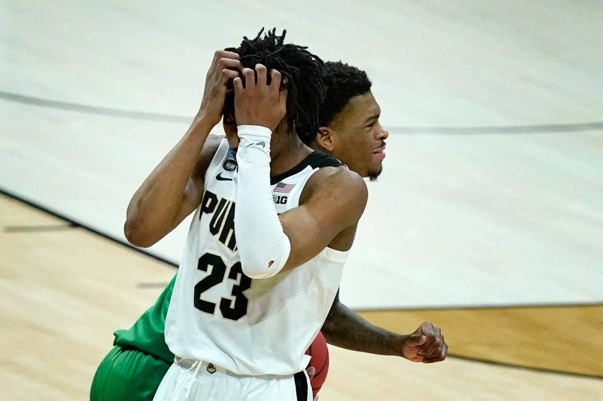 Purdue’s Jaden Ivey (23) covers his face as North Texas’s Javion Hamlet runs past during overtime of a first-round game in the NCAA men’s college basketball tournament at Lucas Oil Stadium, Friday, March 19, 2021, in Indianapolis. North Texas defeated Purdue 78-69 in overtime. 