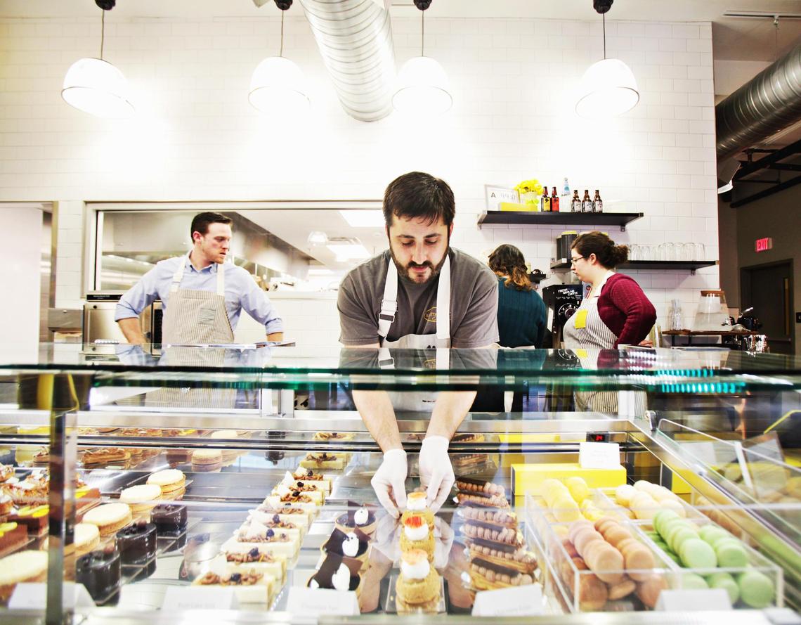 Daniel Benjamin, center, arranges baked goods at the artful French pastry shop, lucettegrace.