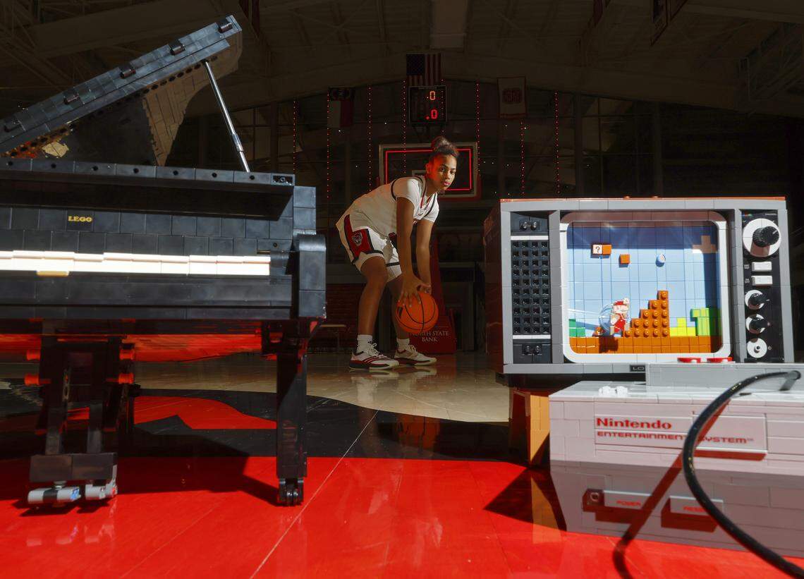 N.C. State sophomore guard Zamareya Jones, photographed on Saturday, Jan. 3, 2026, at Reynolds Coliseum, poses for a portrait with Grand Piano and Nintendo Entertainment System Lego sets she constructed. 