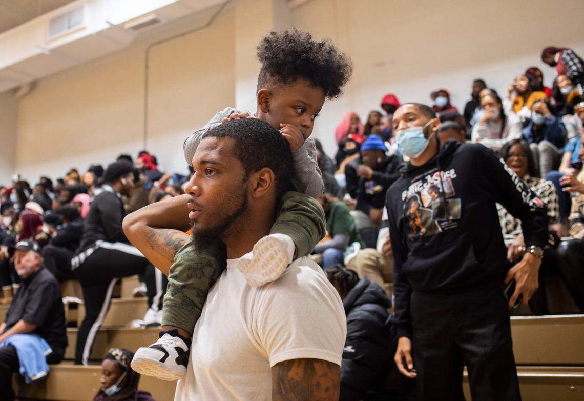 Trey Sumler Sr., the head basketball coach at Nash Central High School in Rocky Mount, N.C., and his 1-year-old son, Trey Jr., await the start of the Kinston High and Farmville Central game at the inaugural Brandon Ingram MLK Showcase in Kinston, N.C on Saturday, Jan. 15, 2022.