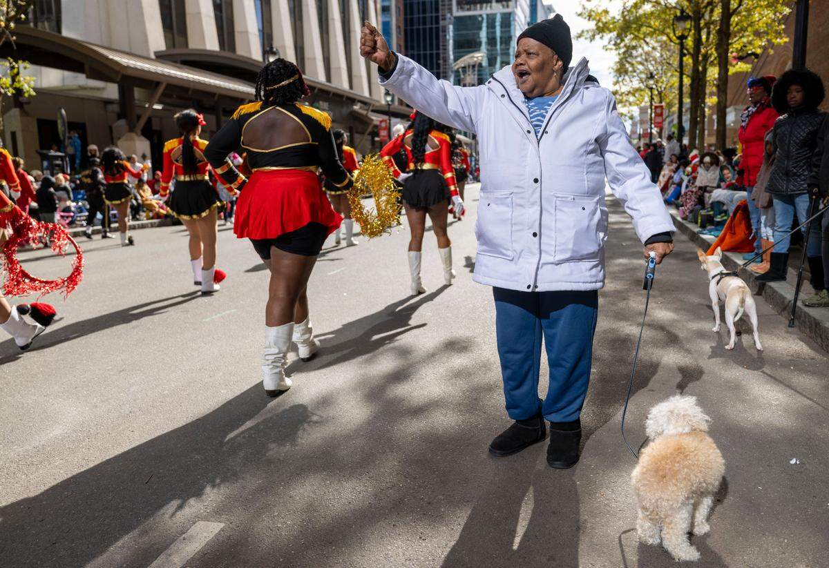 Lana Walton with her dog ‘Dusty’ in tow, shows some love for the Helping Hand Mission Marching Band during the 80th annual Raleigh Christmas Parade on Saturday, November 23, 2024 in Raleigh, N.C.